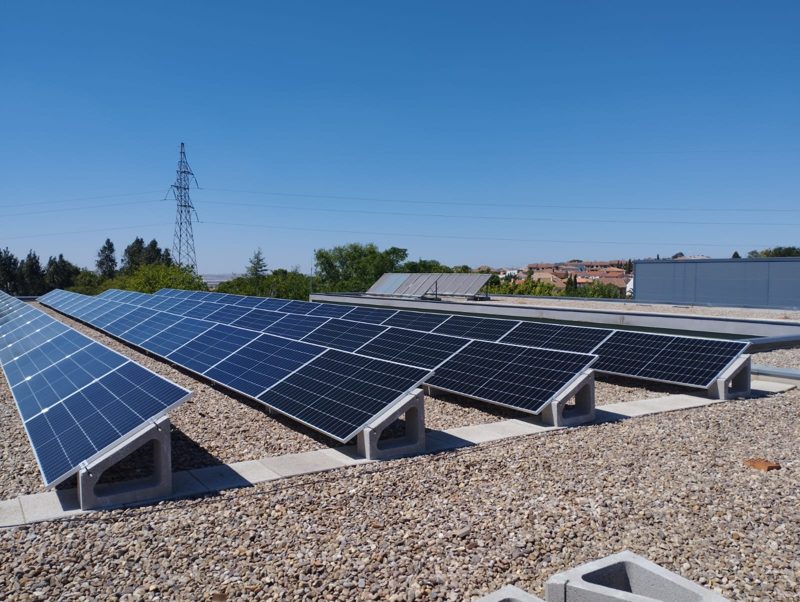 Filas de paneles solares con estructura inclinada sobre una cubierta plana de grava